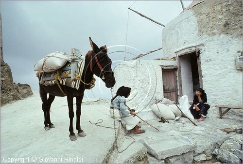 GREECE (Dodecanese) Karpathos Island - GRECIA (Dodecanneso) Isola di Scarpanto - Olimbos - antico paese arroccato sul crinale ed isolato a nord dell'isola - le donne con i sacchi di farina prodotta dall'antico mulino a vento