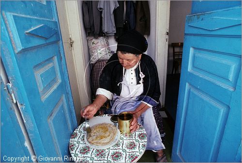 GREECE (Dodecanese) Karpathos Island - GRECIA (Dodecanneso) Isola di Scarpanto - Olimbos - antico paese arroccato sul crinale ed isolato a nord dell'isola - le donne preparano le "pitte" all'interno  dall'antico mulino a vento