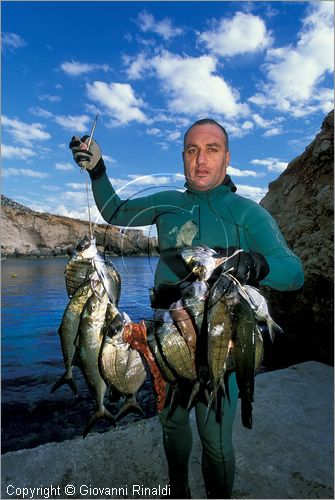 MALTA - MALTA ISLAND - un pescatore subacqueo con il suo carniere sulla costa sud occidentale presso Ghar Lapsi