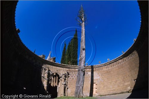 "LA SCARZUOLA E LA CITTA' BUZZIANA"
Montegabbione (TR)
A fianco del convento Francescano della Scarzuola, l'architetto Tommaso Buzzi nel 1956 progett ed edific la sua "Citt Ideale", concepita come una Grande Macchina Teatrale piena di simbolismi ed allegorie.
Il Teatrino di Ciparisso
veduta dell'interno con il grande cipresso secco
al di fuori si vede la fila di cipressi dell'organo arboreo