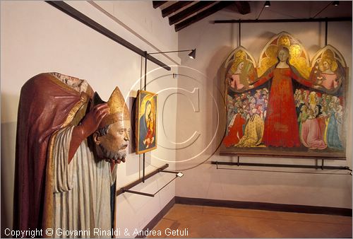 ITALY - PIENZA (SI) - Museo Diocesano d'Arte Sacra - sala 2: veduta della sala con in fondo la grande tavola della Madonna della Misericordia (Bartolo di fredi - 1364), in primo piano statua lignea di San Regolo a Palazzo Massaini (Domenico di Niccol dei Cori - 1430-40)