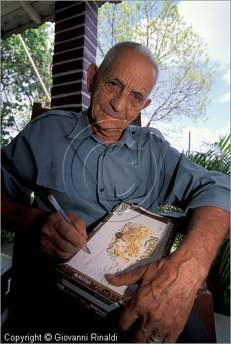 CUBA - (Pinar del Rio) - Alejandro Robaina firma una scatola di sigari di sua produzione nella sua casa in mezzo alle  piantagioni di tabacco nella zona tra San Luis e San Juan y Martinez, dove si produce il miglior tabacco dell'isola e del mondo