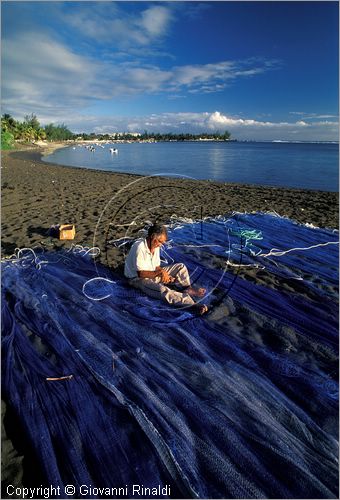 LA REUNION (Indian Ocean) - Etang Sal les Bains - la spiaggia a nord - pescatore che aggiusta la rete