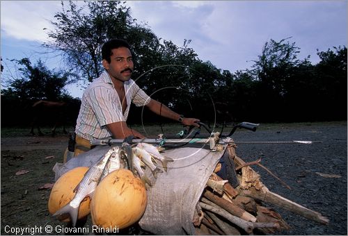 CUBA - (Baracoa) - un pescatore in bicicletta con il suo raccolto presso Porto Santo