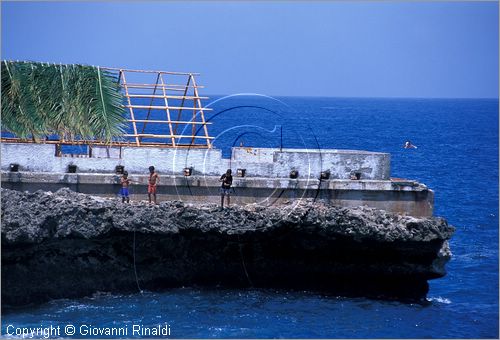 CUBA - Baracoa - bambini che pescano dalla scogliera