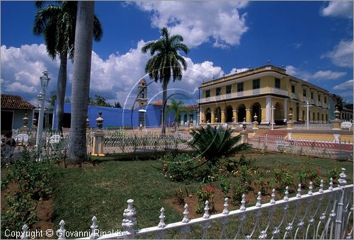 CUBA - Trinidad - Plaza Mayor, la piazza terrazzata con giardini, palme, inferriate, lampioni e vasi in ceramica - dietro  visibile il Palazzo Brunet