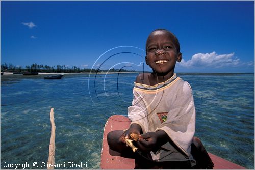 TANZANIA - ZANZIBAR  (Oceano Indiano) - Kizimkazi (estremit sud dell'isola) - un bambino con piccoli oggetti in legno di artigianato locale