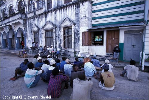 TANZANIA - ZANZIBAR  (Oceano Indiano) - Stone Town - guardando la televisione sotto all'edificio Bharmal